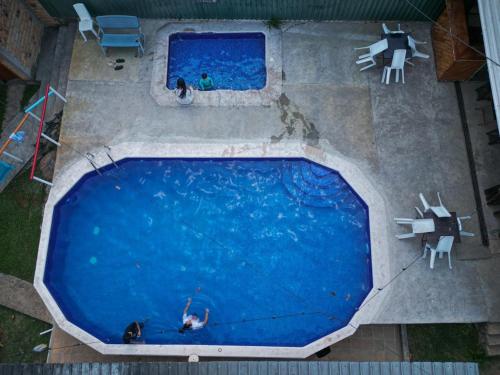 an overhead view of a large swimming pool with two people in it at Hotel Villas del Valle in Valle de Ángeles
