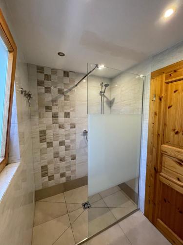 a bathroom with a shower with a glass door at Unser Landhaus - Lastering Ferienhäuser & Apartments in Wettringen