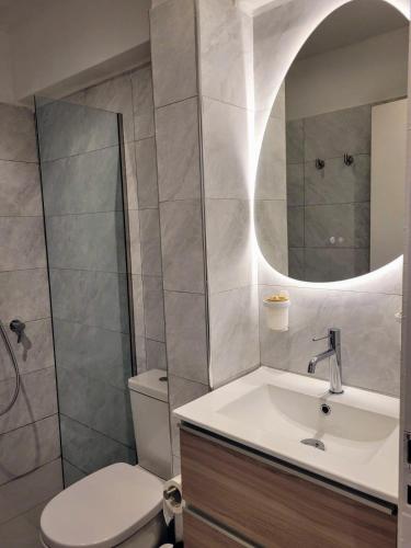 a bathroom with a sink and a toilet and a mirror at Athens Pearl in Athens