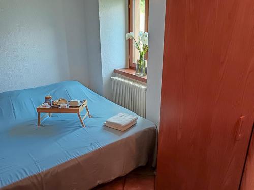a room with a bed with a table and a window at Bel Pace in Sorico
