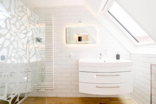 a white bathroom with a sink and a shower at ELSE in der 'Stranddistel' in Langeoog