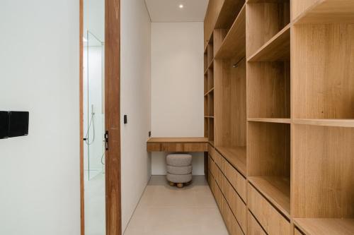 a walk in closet with wooden shelves and a shower at Brandnew 4BR Luxury Estate next to Beach & views in Cemagi