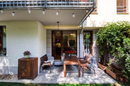 a patio with a wooden table and chairs at Apartment with garden in Prague 6 in Prague