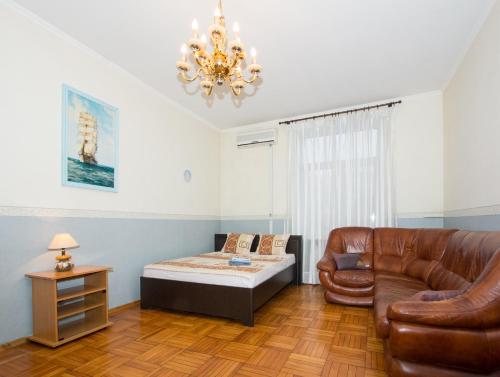een slaapkamer met een bed, een bank en een kroonluchter bij ApartLux Park Pobedy in Moskou
