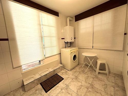 a small kitchen with a washing machine and a table at Apartamento Welcome Grañamar in Sanxenxo