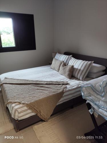 a bed sitting in a room with a window at Tapada das Carvalhas in Castelo Branco