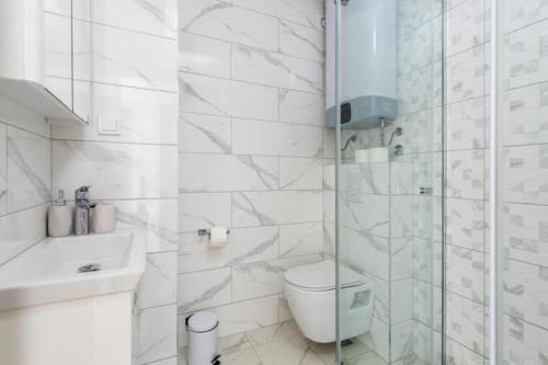 a white bathroom with a toilet and a shower at Apartments Port View in Herceg-Novi