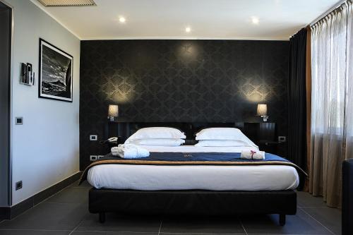a bedroom with a large bed with a black headboard at Best Western JFK Hotel in Naples