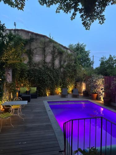 une piscine avec éclairage violet dans une arrière-cour dans l'établissement Avignon Campagne, à Avignon