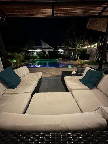 two white couches sitting in front of a pool at night at Casa Vida Villas in Potrero