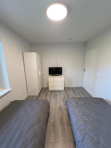 une chambre avec un lit et une télévision dans l'établissement Pušų Sodas, à Birštonas