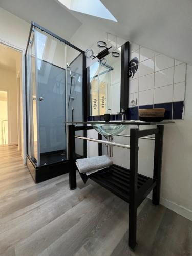 La salle de bains est pourvue d'une table en verre et d'une douche. dans l'établissement Maison Charmante - Centre de Ville - Proche gare, à La Roche-sur-Yon