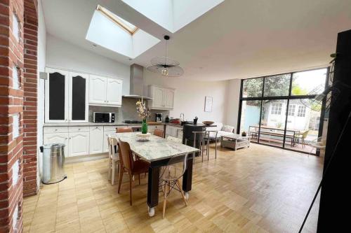 une cuisine et un salon avec une table et des chaises dans l'établissement Maison Charmante - Centre de Ville - Proche gare, à La Roche-sur-Yon