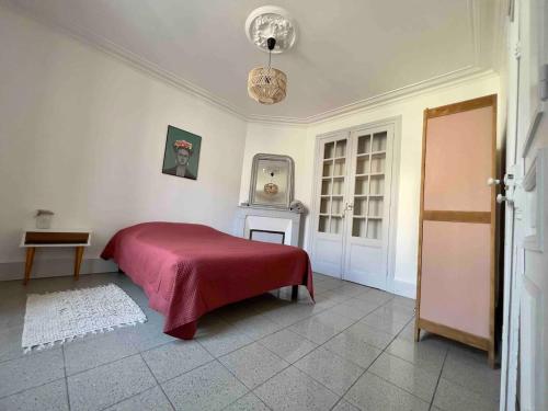 une chambre avec un lit avec une couverture rouge dans l'établissement Maison Charmante - Centre de Ville - Proche gare, à La Roche-sur-Yon