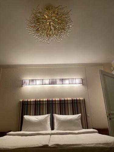 a chandelier hanging above a bed in a room at Gulbės Apartamentai in Anykščiai