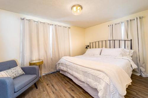a bedroom with a bed and a blue chair at Stylish 2BR n Old Town Greenwood in Greenwood