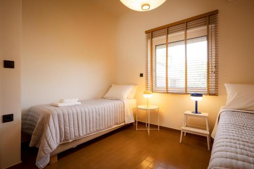 a bedroom with two beds and a window at Mantarini House in Chania Town