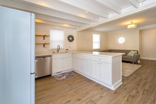 a kitchen with white cabinets and a living room at Stylish 2BR n Old Town Greenwood in Greenwood