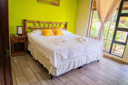 a bedroom with a bed with yellow walls at Banana Palms Hotel in Rio Dulce