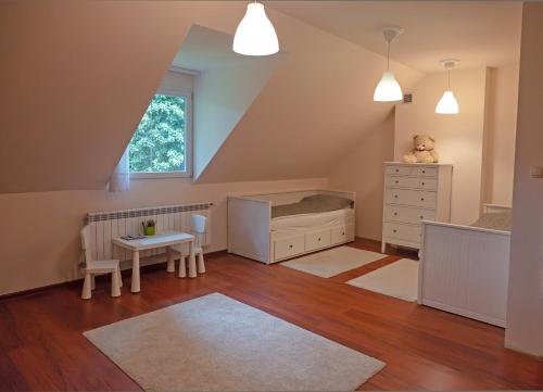 a baby room with a bed and a table at Comfortable 4 bedroom villa outdoor wood-fired sauna Warsaw in Magdalenka