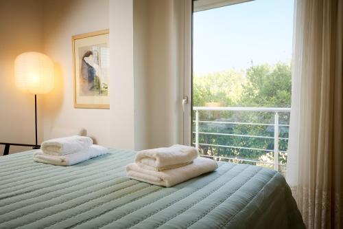 a bedroom with two towels on a bed with a window at Mantarini House in Chania Town