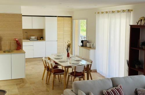 AubussarguesにあるMaison Villa Malon Sud Aubussargues Uzès Nîmes avec piscineのテーブルと椅子のあるキッチンとダイニングルーム