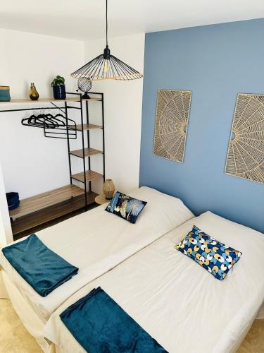 deux lits dans une chambre aux murs bleus dans l'établissement Maison Villa Malon Sud Aubussargues Uzès Nîmes avec piscine, à Aubussargues