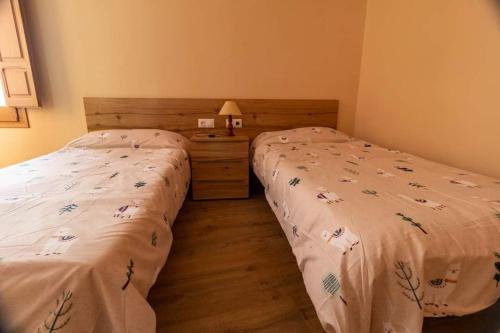 two twin beds in a bedroom with a night stand at CAL METGE in Benissanet