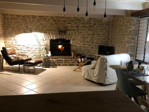 Il comprend un salon doté d'un mur en briques et d'une cheminée. dans l'établissement Penty Bretagne, à Penmarcʼh