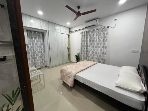 a bedroom with a bed and a ceiling fan at FG penthouse in Kondapur