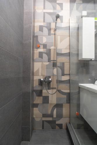 a shower with a glass door in a bathroom at Lumi Apartments in Gevgelija