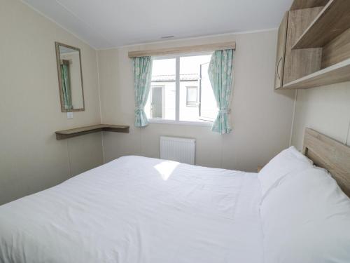 a white bed in a bedroom with a window at Manor House Gold 2 Bedroom 20C in Maryport
