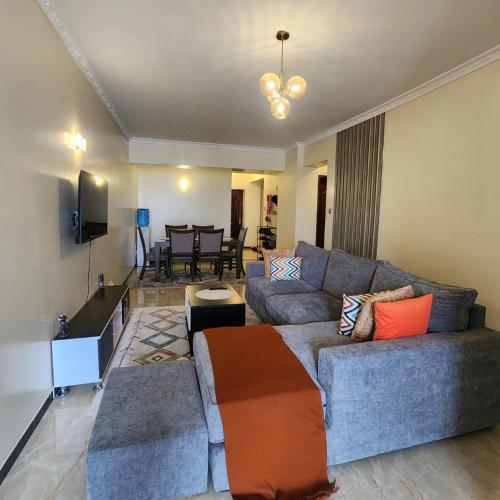 a living room with a couch and a table at Kilimani Quiet Skynest in Nairobi