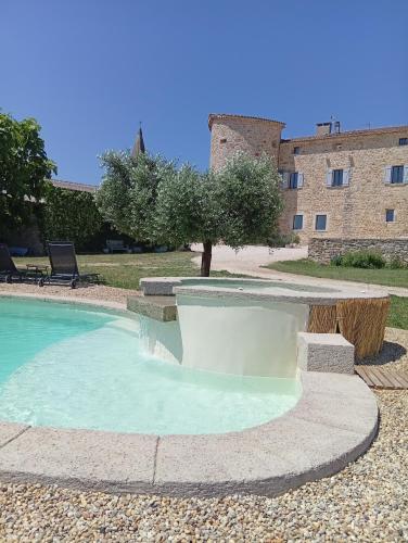 une piscine dans une cour avec un bâtiment en arrière-plan dans l'établissement coeur de famille, à Bessas
