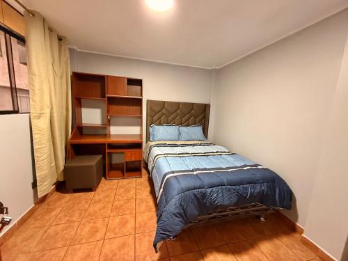 een kleine slaapkamer met een bed en een bureau bij Jaichi KIREI in Cajamarca