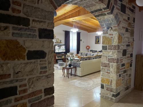 an archway in a living room with a stone wall at Stone House Berat in Dushnik