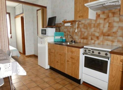 Il comprend une cuisine équipée d'une cuisinière blanche et d'un évier. dans l'établissement Gîte Bourdeilh en Périgord, à Rouffignac-Saint-Cernin-de-Reilhac