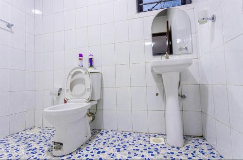 a bathroom with a toilet and a sink at Then Den Soroti White & Gray in Soroti