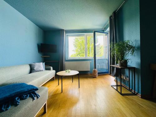 a living room with a couch and a table at Fewo A am Theater mit Terrasse und Balkon in Stralsund