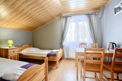 a bedroom with two beds and a table and chairs at Rezydencja Karnat in Karpacz