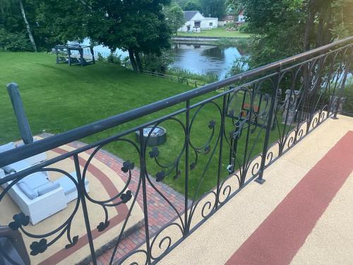 a railing on a balcony with a view of a river at Gulbės Apartamentai in Anykščiai