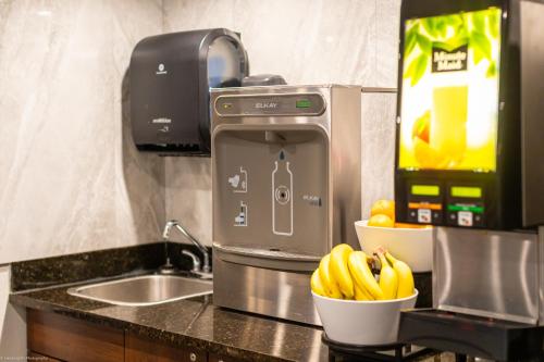 a kitchen counter with a juicer and a bowl of bananas at Home Inn and Suites Lloydminster in Lloydminster