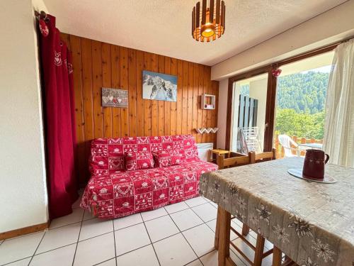 een woonkamer met een rode bank en een tafel bij À Notre-Dame-de-Bellecombe: charmant appart 4-5 pers, terrasse sud, animaux OK - FR-1-505-56 in Notre-Dame-de-Bellecombe