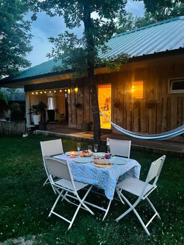 a table and chairs in the yard of a house at Country Cottage & Spa in Labalme