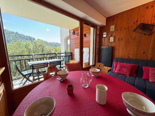 une pièce avec une table rouge avec vue sur un balcon dans l'établissement Appartement avec balcon au calme et vue sur montagne, parking privé - FR-1-505-101, à Notre-Dame-de-Bellecombe