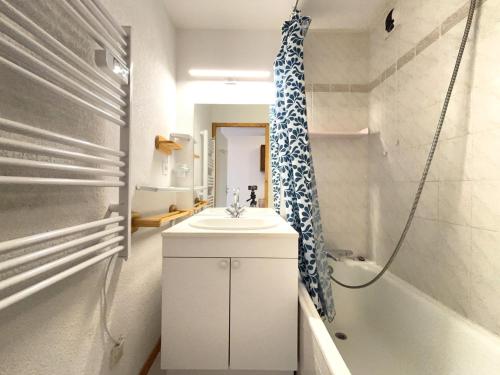 une salle de bain avec un lavabo, une douche et une baignoire dans l'établissement Charmant duplex avec parking et équipements bébé - FR-1-505-64, à Notre-Dame-de-Bellecombe