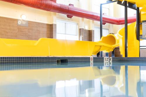 a pool with a yellow slide in a building at Home Inn and Suites Lloydminster in Lloydminster
