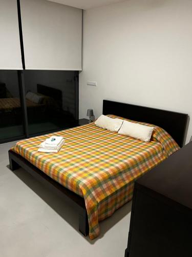 ein Schlafzimmer mit einem Bett mit einer karierten Decke in der Unterkunft Arrenquinha Guesthouse # Margarida in São Vicente Ferreira