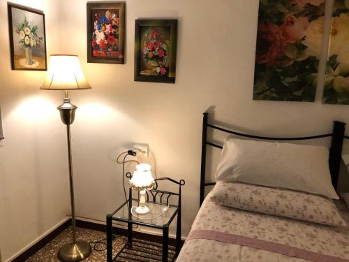 a bedroom with a bed and a table with a lamp at B&B Rosa in Samarate