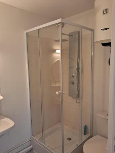 La salle de bains est pourvue d'une douche en verre et de toilettes. dans l'établissement Le temps d'une pause, à Villers-sur-Mer